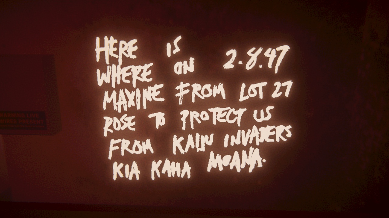It is a photo taken in Umurangi Generation. The photo is of some graffiti which reads, 
                “Here is where on 2.8.47, Maxine from lot 27 rose to protect us from Kaiju invaders. Kia kaha Moana.” 